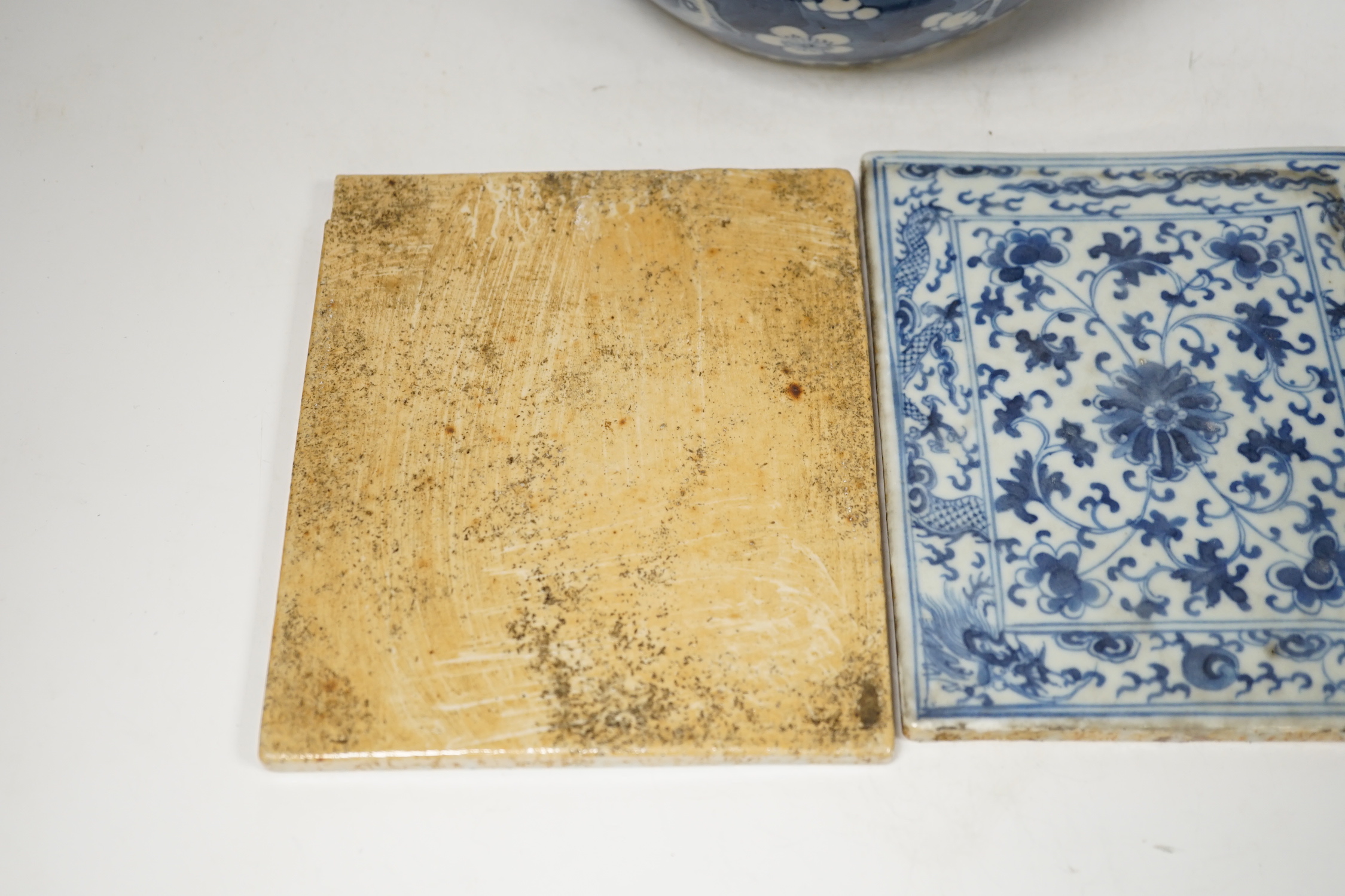 A 19th century Chinese blue and white prunus jar and cover, together with two similar tiles, jar 21cm